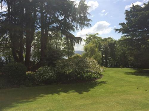 a green yard with trees and a field of grass at Old Drynie House, in Inverness