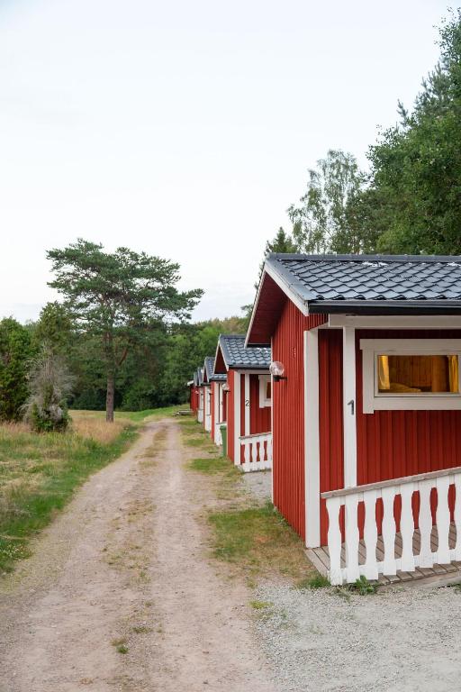 a row of red buildings on a dirt road at Maja Camping in Bottnaryd
