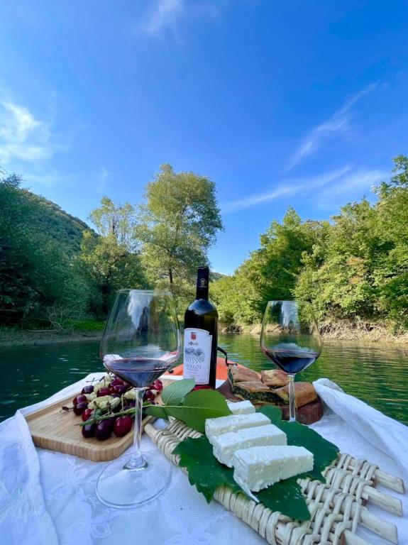 a table with two glasses of wine and cheese at Alpeta Agrotourism & Winery - Roshnik , Berat in Berat