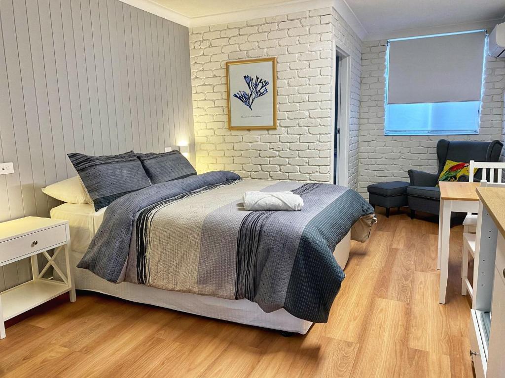 a bedroom with a bed and a television in it at Bay House Motel in Bateau Bay