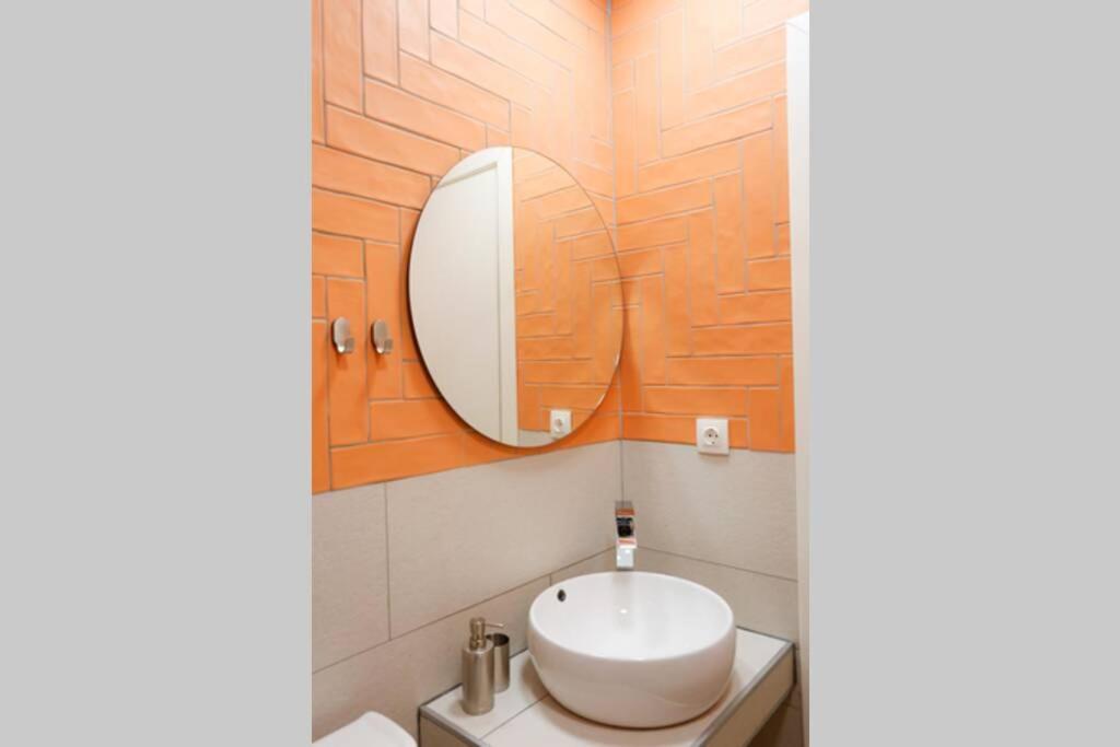 łazienka z białą umywalką i lustrem w obiekcie Valory #5 Aesthetic Stay w Salonikach