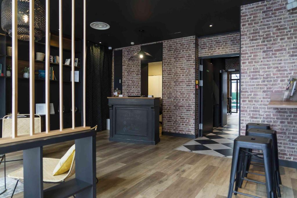 a room with brick walls and a bar with a counter at Hotel SUB in Asnières-sur-Seine