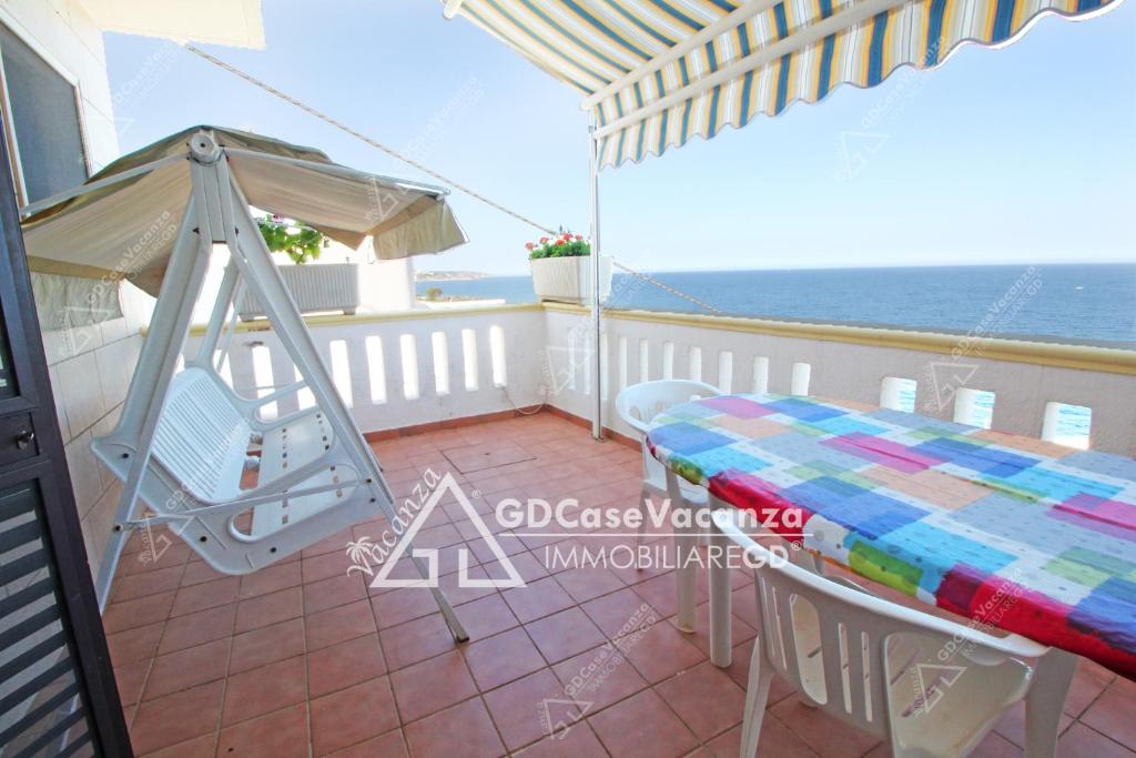 - Balcón con mesa y columpio en GD Case Vacanza - Veranda sul mare - en Andrano