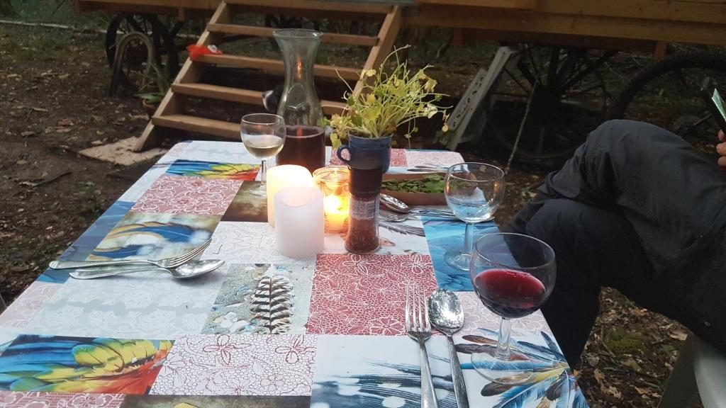 a picnic table with glasses of wine and a candle at Charming Cottage in Chauminet in Sougères-en-Puisaye