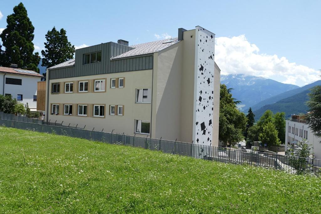 um edifício no topo de uma colina gramada ao lado de um edifício em FinKa em Malles Venosta