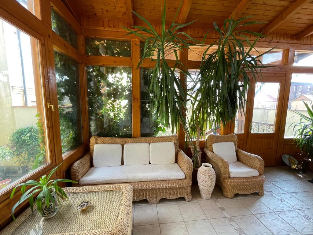 un porche cubierto con 2 sillas y plantas en Lyrius Vendégház - Debrecen, en Debrecen