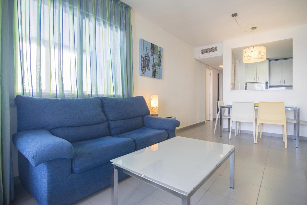 sala de estar con sofá azul y mesa en Apartamentos Hipocampos Calpe Rent Apart, en Calpe