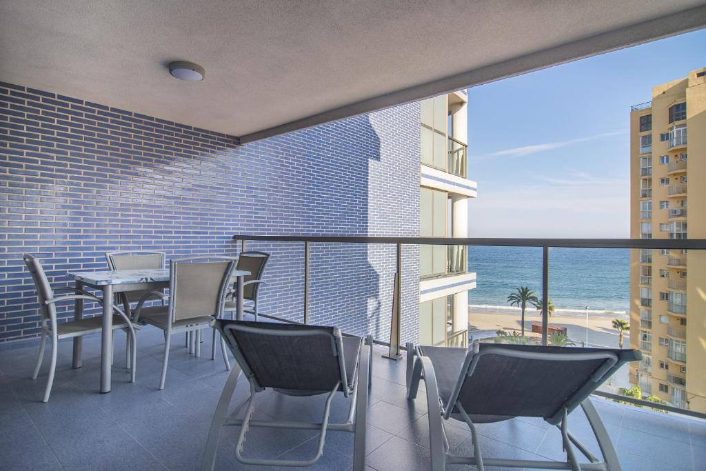a balcony with chairs and a table and the ocean at Apartamentos Hipocampos Calpe Rent Apart in Calpe