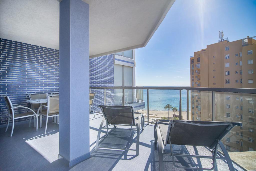 a balcony with chairs and a view of the ocean at Apartamentos Hipocampos Calpe Rent Apart in Calpe