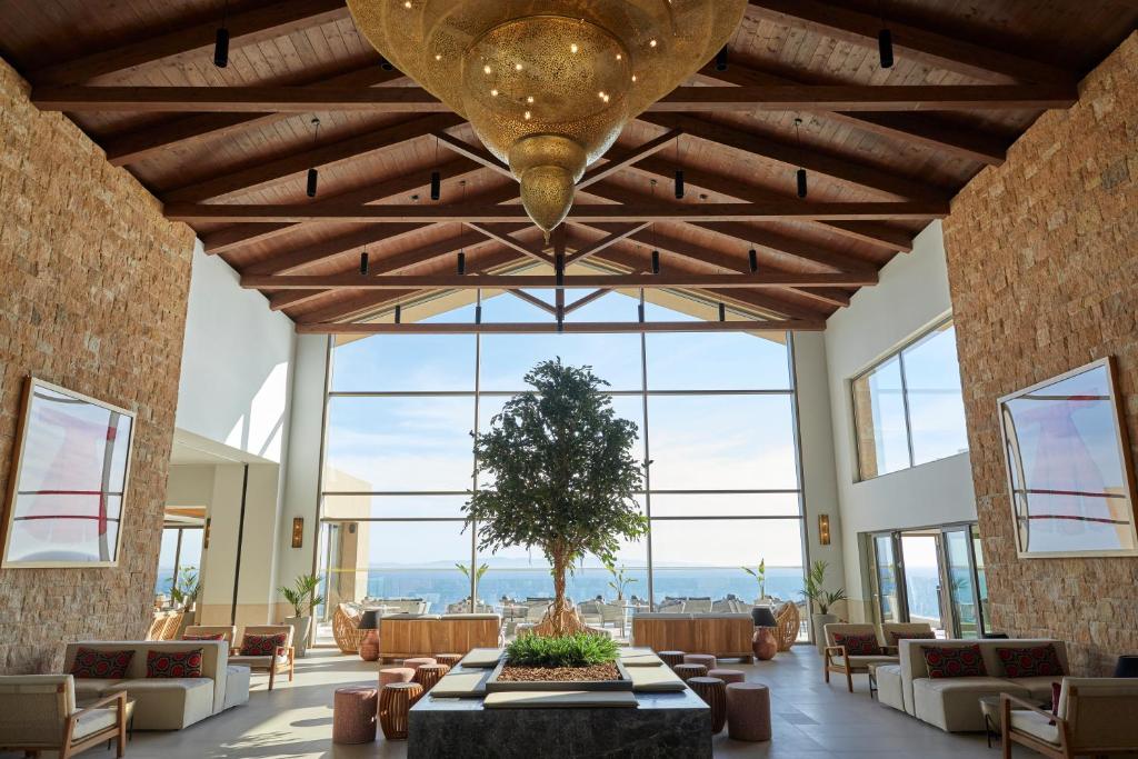 a large lobby with a large ceiling with windows at Elix, Mar-Bella Collection in Perdika