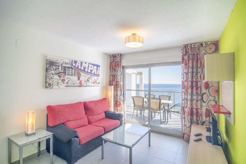 a living room with a couch and a view of the ocean at Apartamentos Hipocampos Calpe Rent Apart in Calpe
