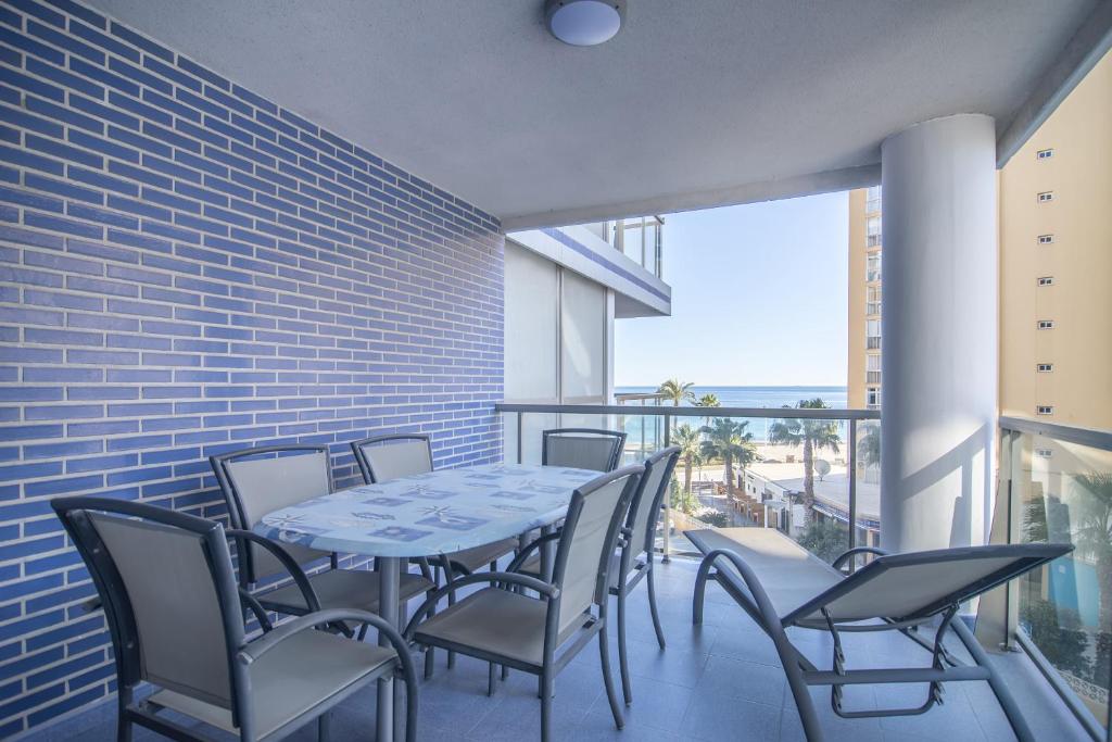 a table and chairs on a balcony with a view of the beach at Apartamentos Hipocampos Calpe Rent Apart in Calpe