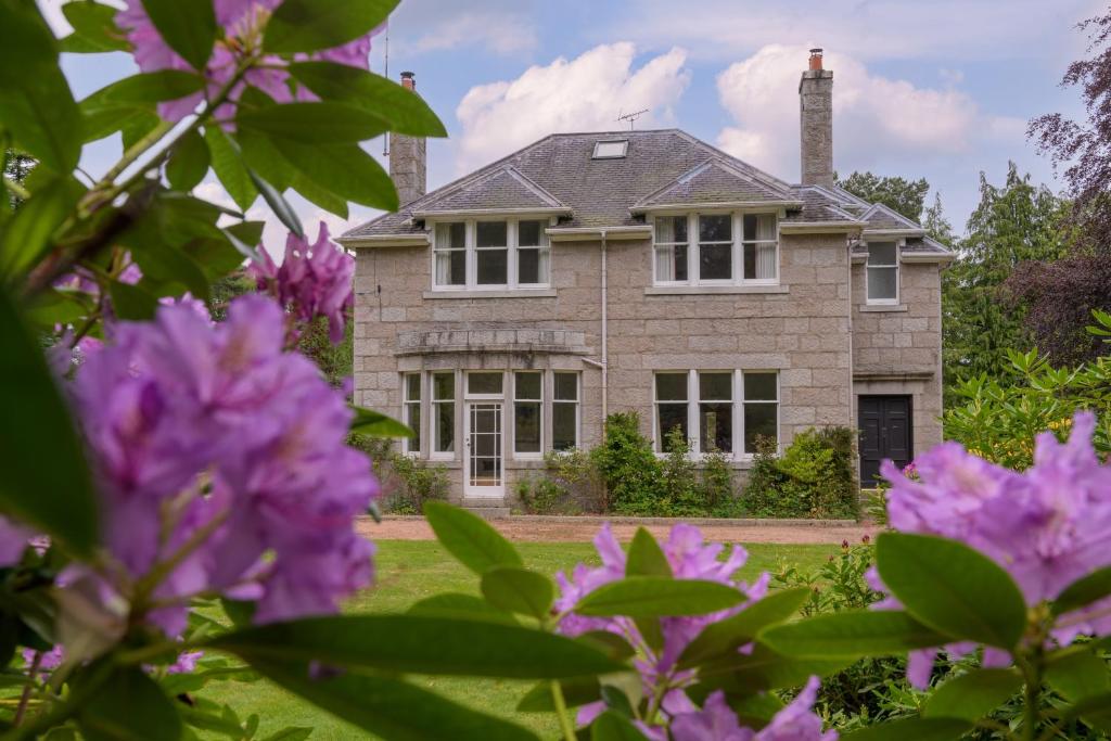 a house with purple flowers in front of it at Haven Retreat Scotland - Large 4 Bed House with Woodland garden, Aboyne ,Royal Deeside in Aboyne