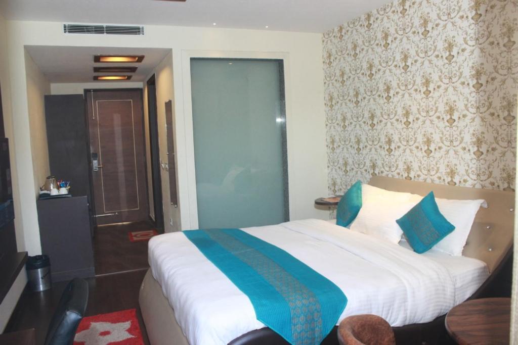 a bedroom with a large bed with blue and white sheets at S S INTERNATIONAL in Dalhousie