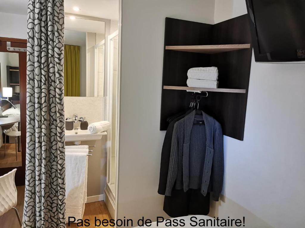 La salle de bains est pourvue d'un sèche-serviettes et d'un lavabo. dans l'établissement A&H PRIVILÈGE Lyon Est - Saint Priest Eurexpo, à Saint-Priest