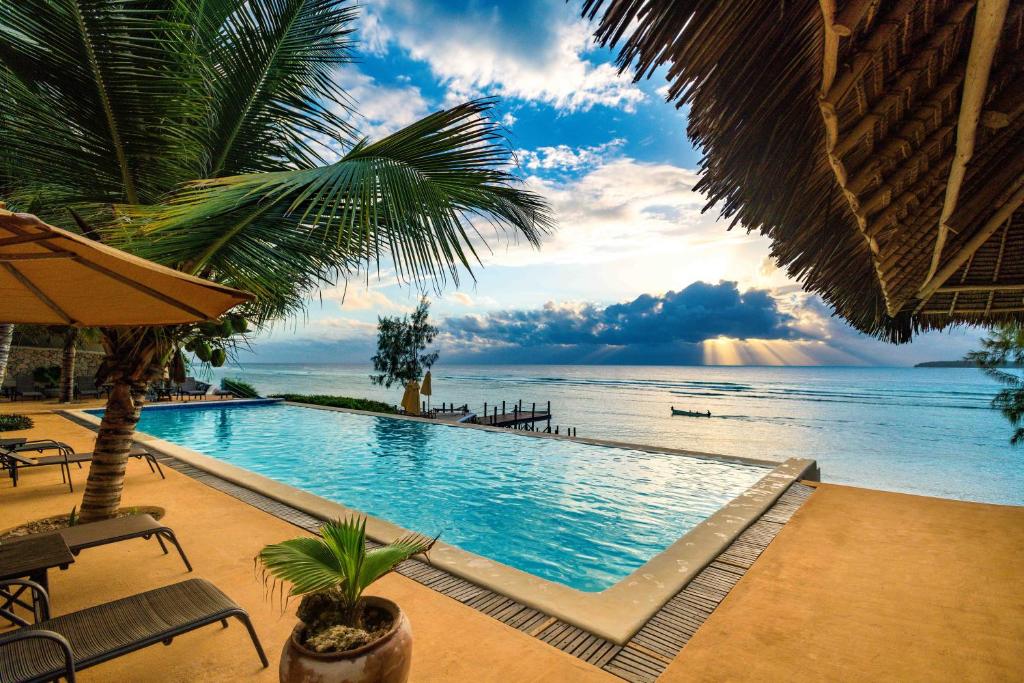 a swimming pool with a view of the ocean at Sunshine Marine Lodge in Matemwe