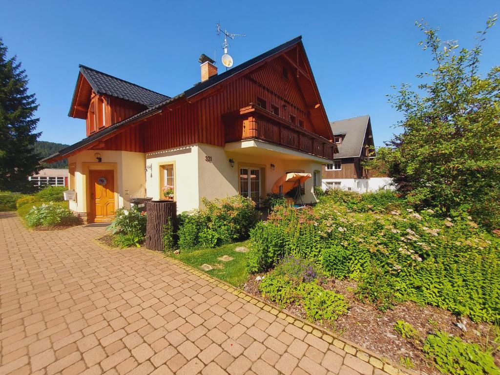 ヤンスケー・ラーズニェにあるApartmány Evaの赤い屋根とレンガ造りの私道のある家