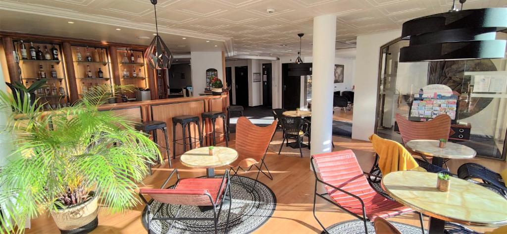 un restaurant avec des tables et des chaises ainsi qu'un bar dans l'établissement Hôtel Le Valois, Cognac Centre, à Cognac