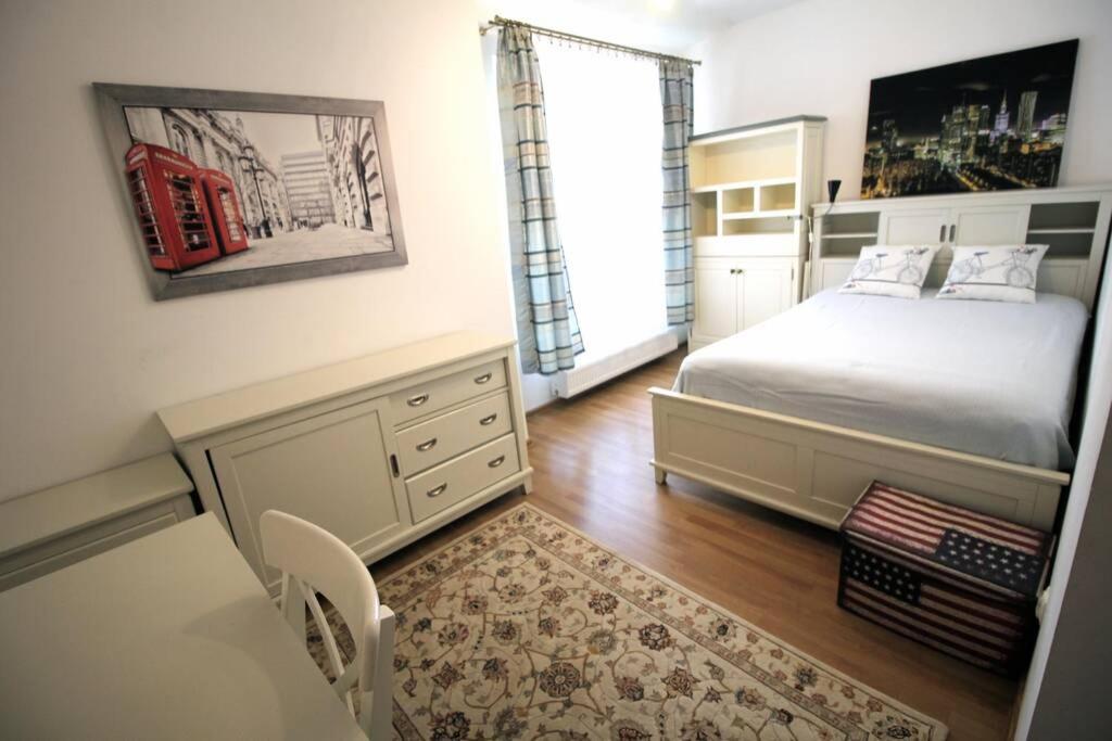 1 dormitorio con cama, escritorio y ventana en Orchidea Apartment en Lublin