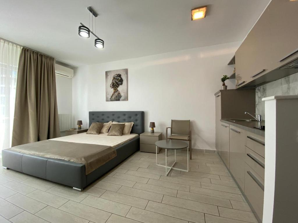 een slaapkamer met een bed en een tafel en een keuken bij De Silva Studio Adia 4 in Mamaia