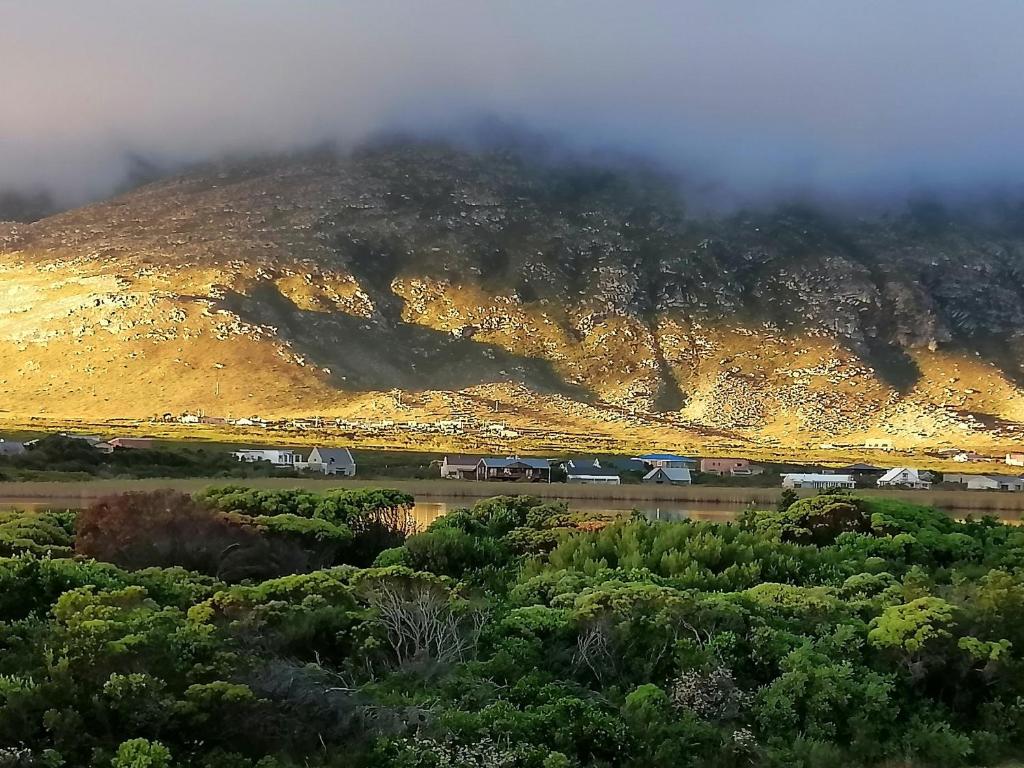 a misty mountain with a train in front of it at Just Chill Betty's Bay in Bettyʼs Bay