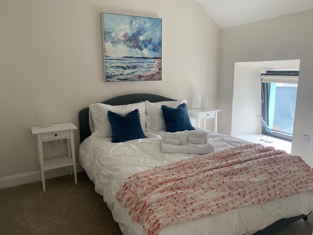 a bedroom with a large white bed with blue pillows at Farm House - Sleeps 7 - Garden - Parking in Cork