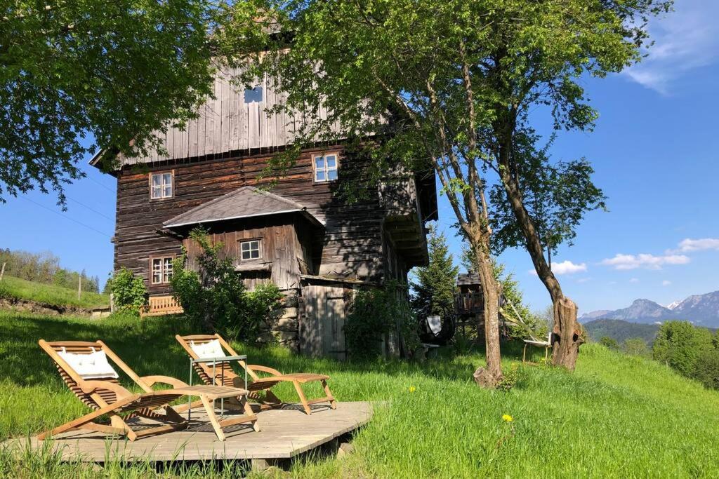 two chairs and an old barn in a field at Lutzmannalm in Lassing