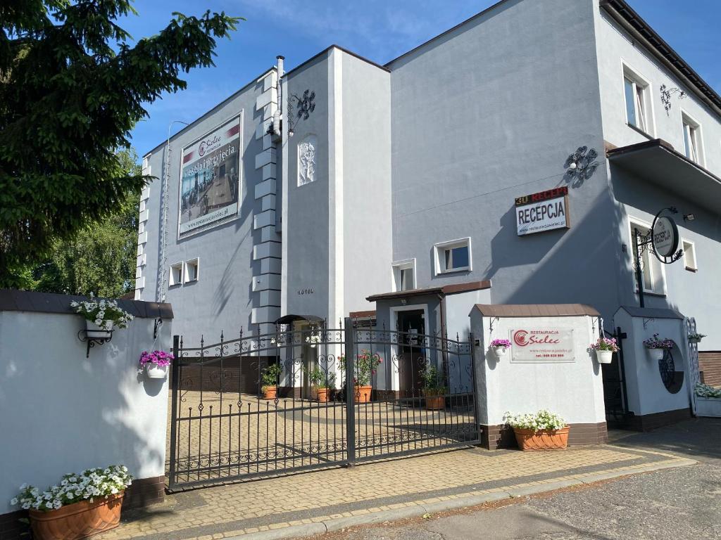 un bâtiment blanc avec une porte devant dans l'établissement Pensjonat Sielec, à Sosnowiec