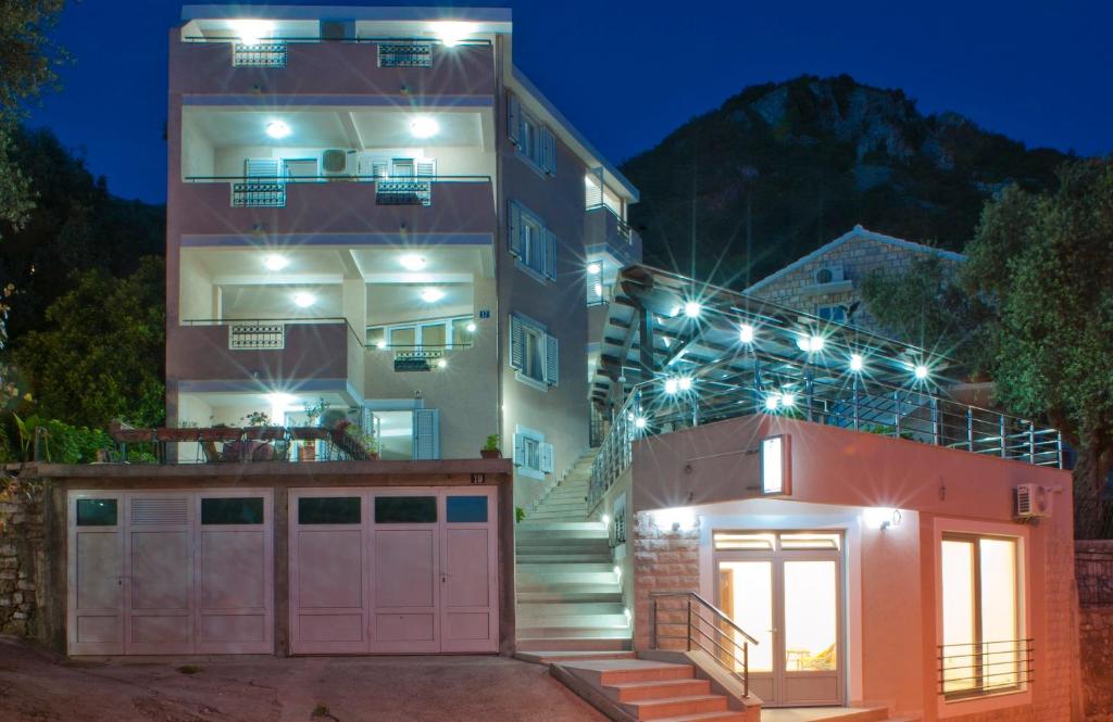 un edificio con una puerta y un garaje por la noche en Apartments Marina, en Sveti Stefan