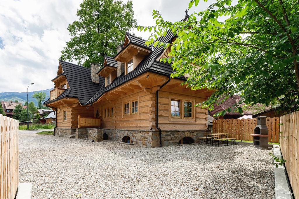 uma grande casa de madeira numa calçada de cascalho em Zasypane Premium House & Sauna in Zakopane by Renters Prestige em Zakopane
