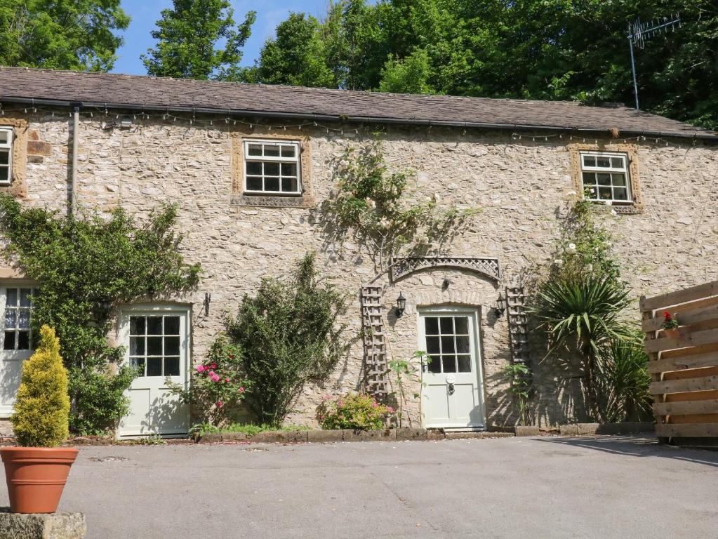 een oud stenen gebouw met twee witte deuren bij The Barn in Buxton