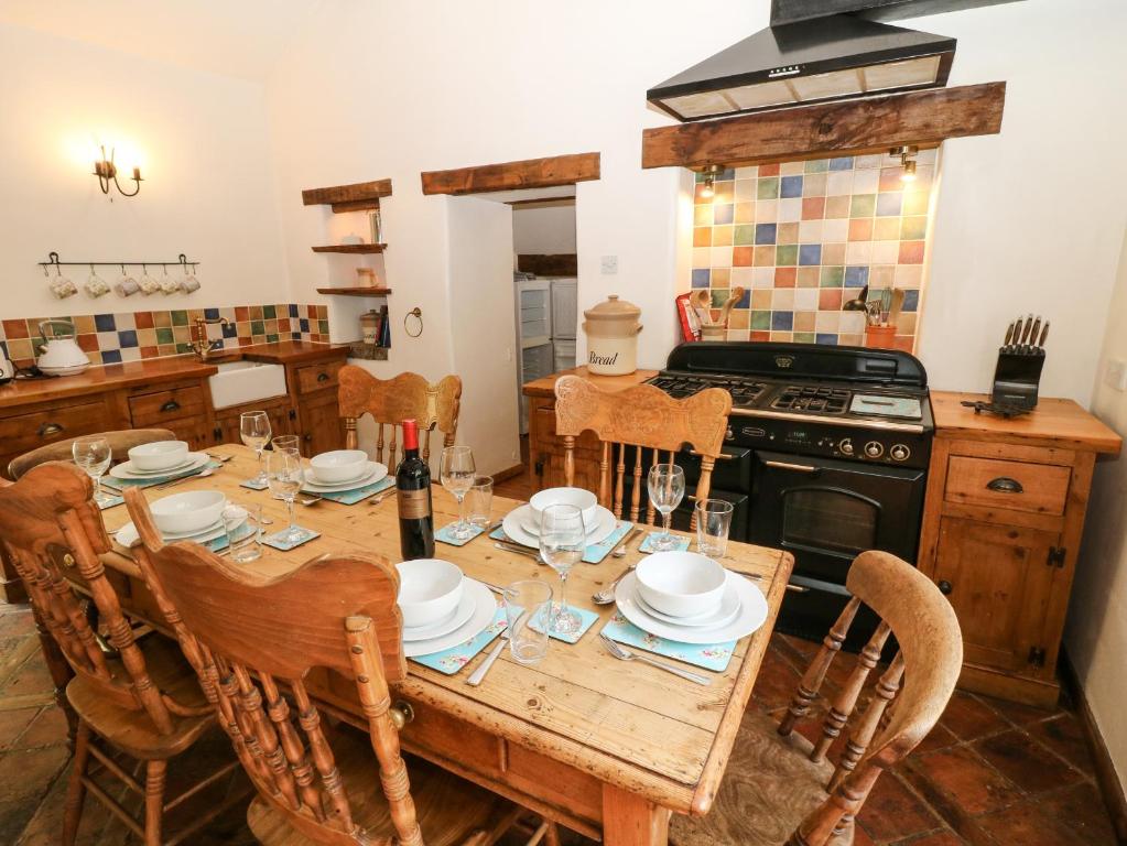 a kitchen with a wooden table with chairs and a stove at The Barn in Buxton