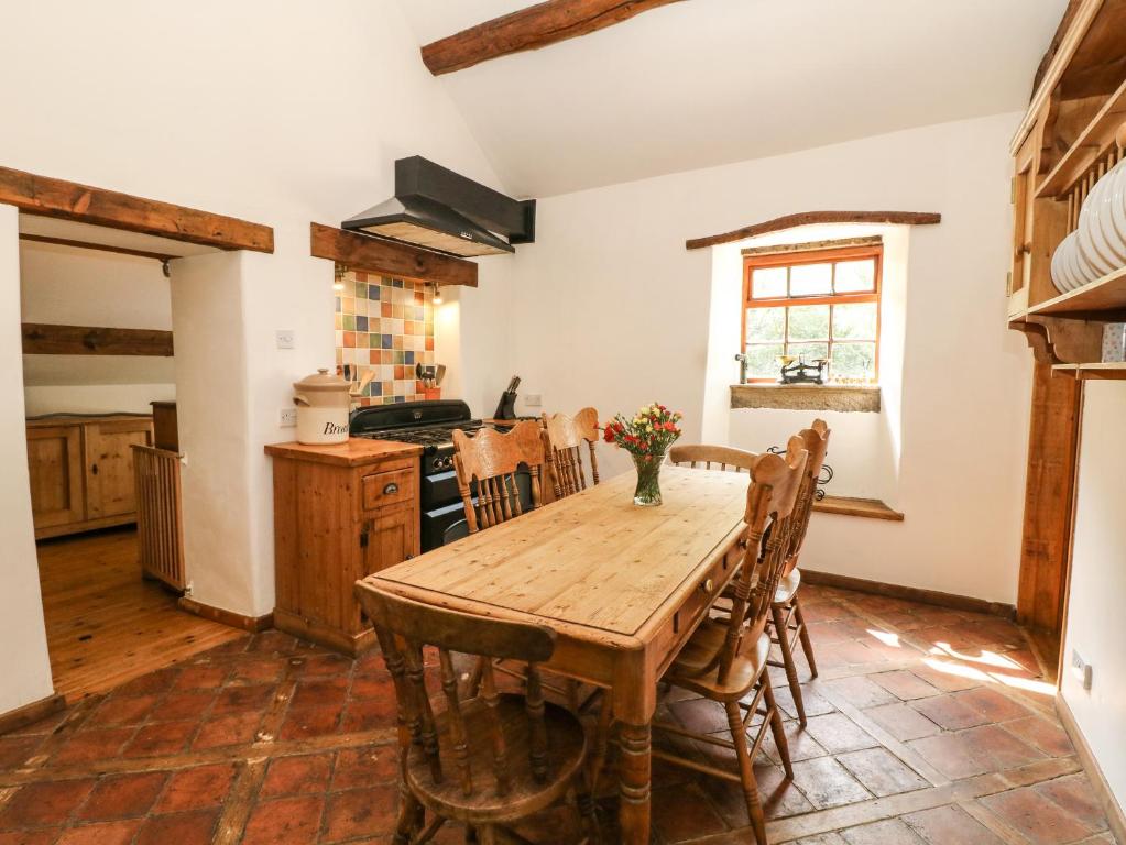 a kitchen with a wooden table and chairs in a room at The Barn in Buxton