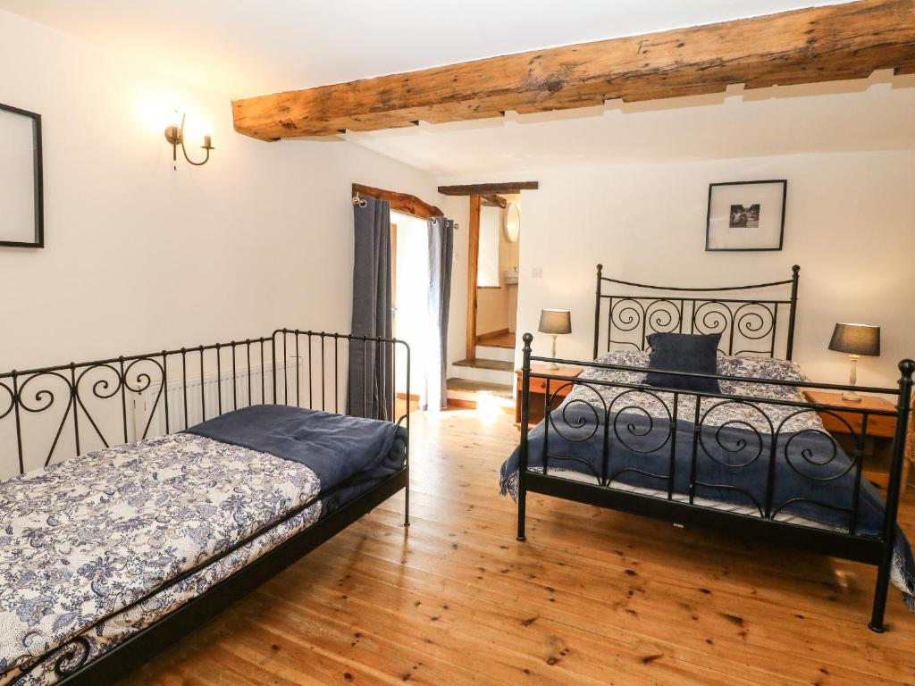 a bedroom with two beds and a wooden floor at The Barn in Buxton