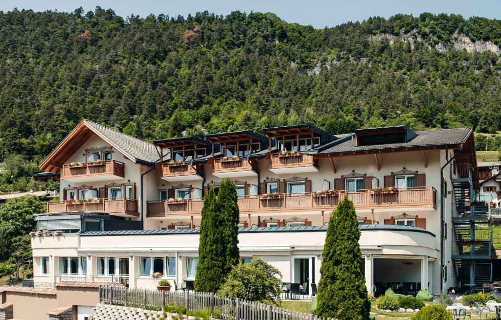 un gran edificio con árboles frente a una montaña en Hotel Ludwigshof & Luvina, en Trodena