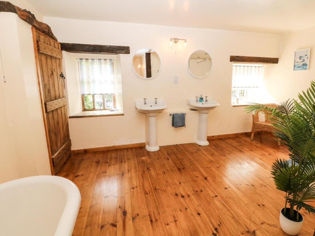 a bathroom with two sinks and two mirrors at The Barn in Buxton