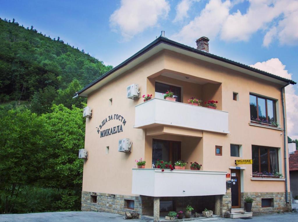 a building with two balconies on the side of it at Guest house Mikaela in Gabrovo