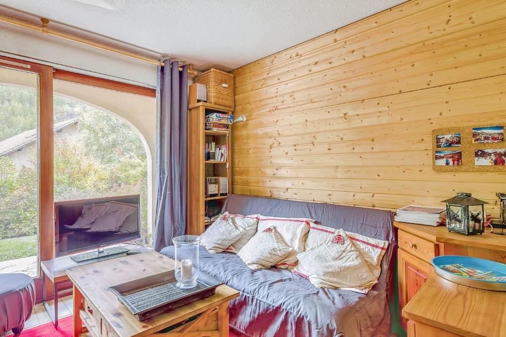 une chambre avec un canapé, une table et une fenêtre dans l'établissement Apartment Near The Slopes La Salle Des Alpes, à La Salle Les Alpes