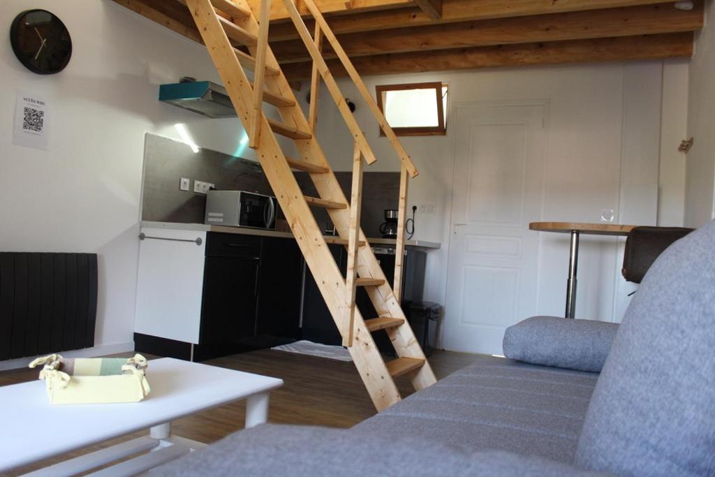 uma sala de estar com escadas que levam a uma cozinha em Studio neuf proche d'Alençon et Le mans em Lonrai