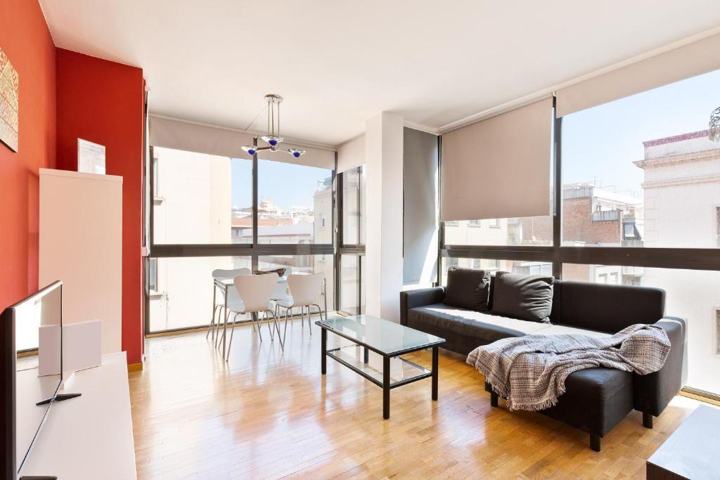 Stay U-nique Apartments Bonsoms في برشلونة: غرفة معيشة مع أريكة وطاولة