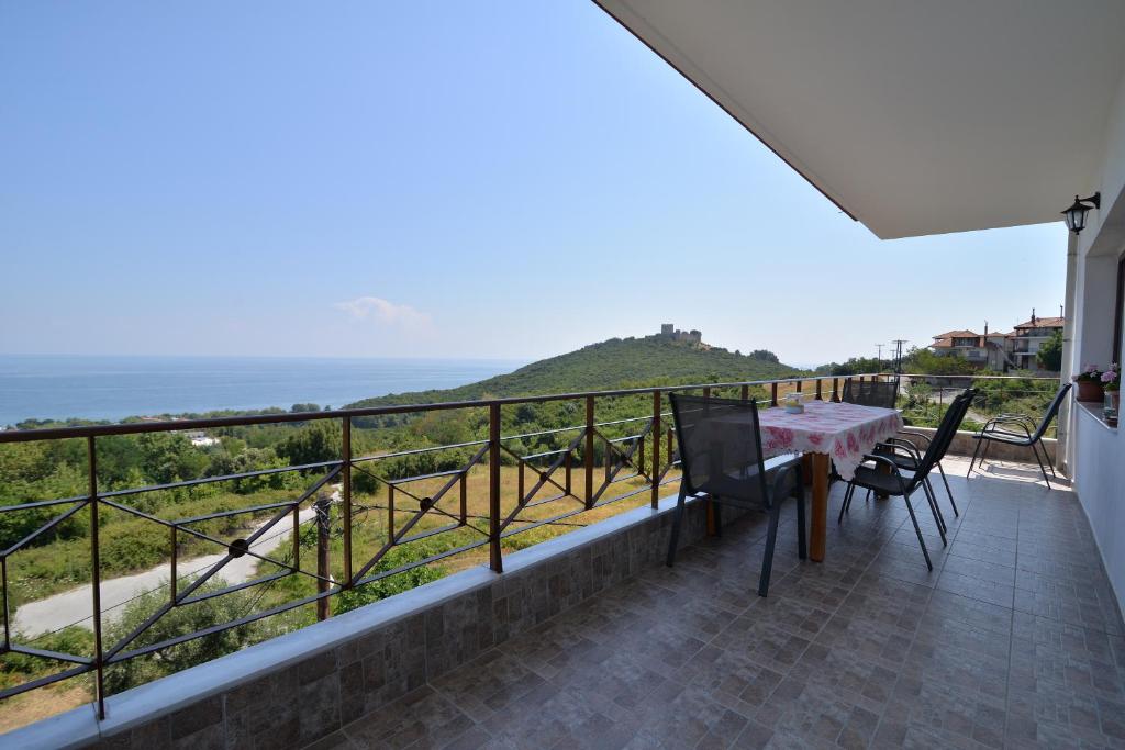a balcony with a table and chairs and the ocean at neos panteleimonas pierias VILLA LAYLA in Neos Panteleimonas