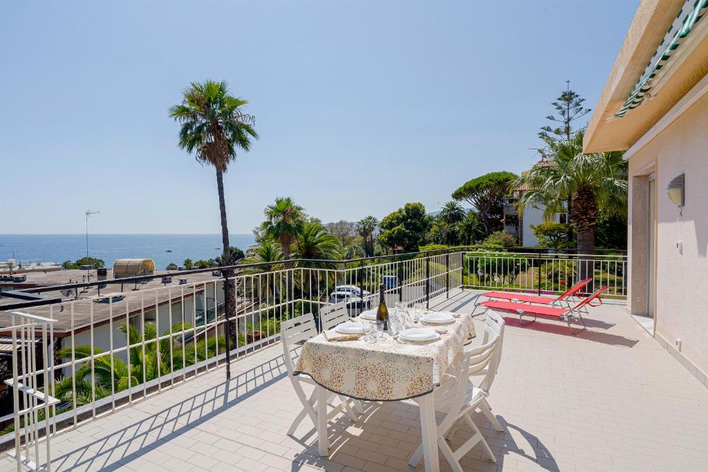 eine Terrasse mit einem Tisch und Stühlen auf dem Balkon in der Unterkunft Tre Ponti Panoramic Seaview Apartment in Sanremo