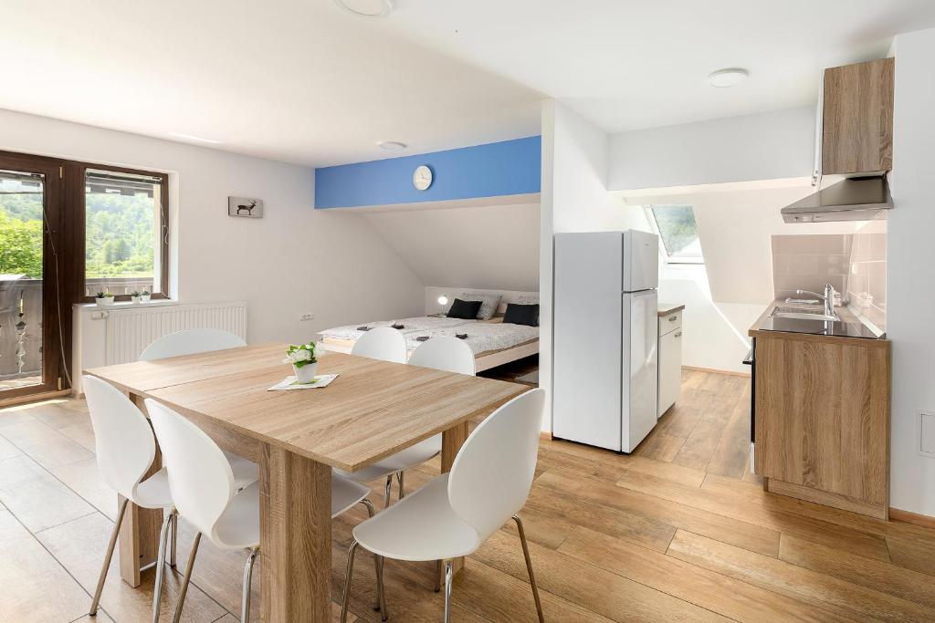 a kitchen and dining room with a wooden table and chairs at Apartmaji Rupnik in Bohinjska Bistrica