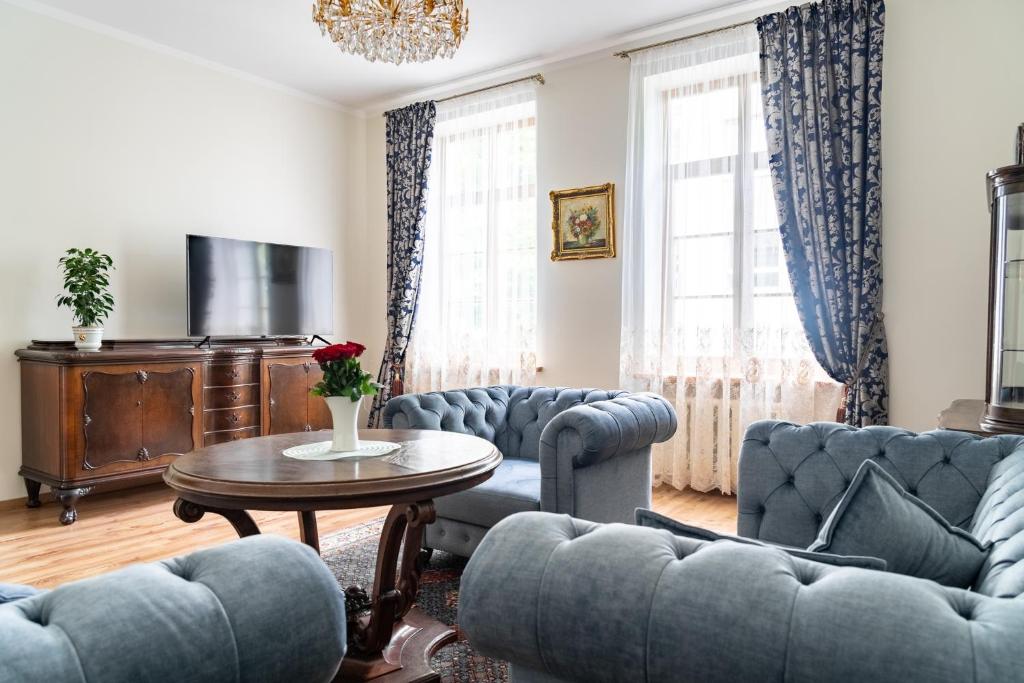 a living room with blue couches and a table at Old Town Cat Apartment in Klaipėda