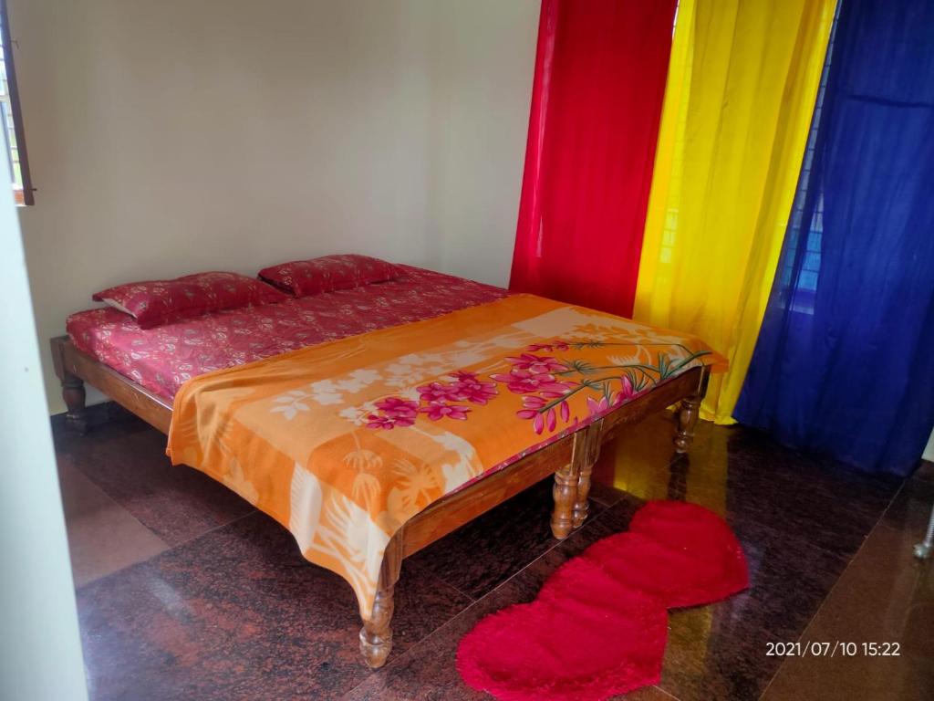 a bed in a room with colorful curtains at Akshay Sweet Home Stay in Mysore