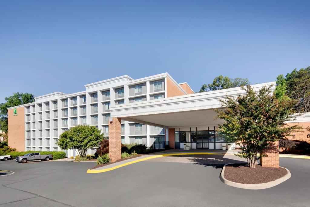 an exterior view of a hotel with a parking lot at Holiday Inn University Area Charlottesville, an IHG Hotel in Charlottesville
