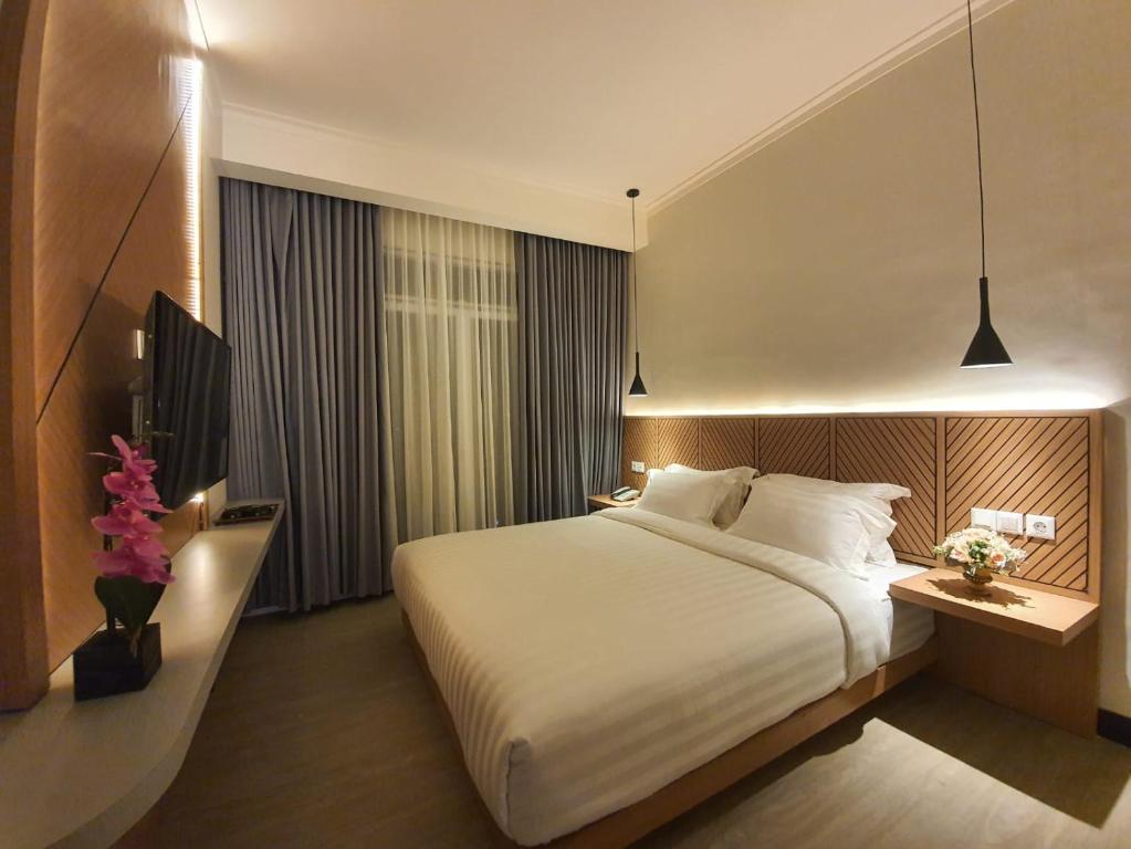 Postel nebo postele na pokoji v ubytování Muara Hotel Bukittinggi