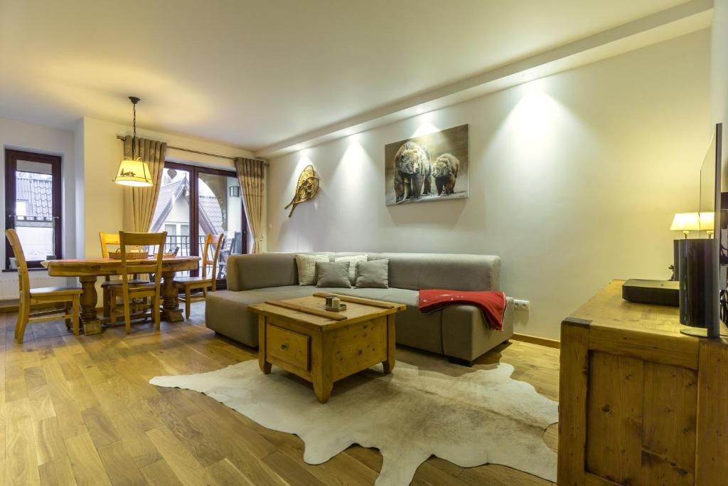 uma sala de estar com um sofá e uma mesa em Apartament Montagne em Zakopane