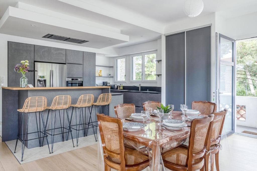 a kitchen and dining room with a table and chairs at Villa Le Deck - Grande maison familliale proche plage in Arcachon