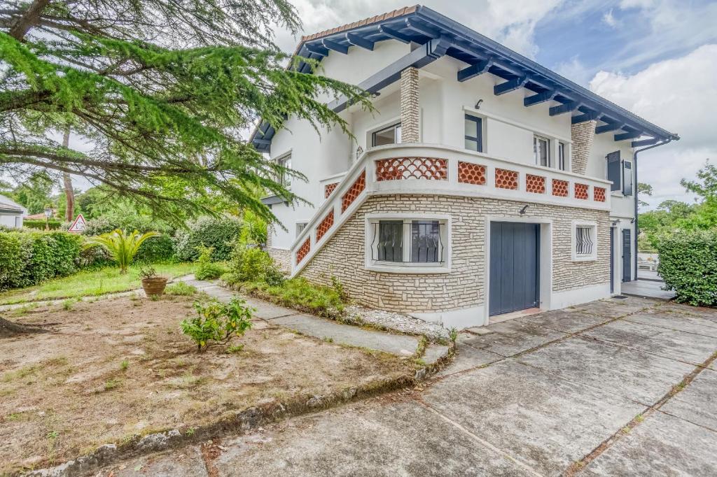 a large white house with a driveway at Villa Le Deck - Grande maison familliale proche plage in Arcachon